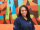 woman in americorps polo stands in front of mural