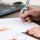 Person writing on paper with an AmeriCorps-branded pen