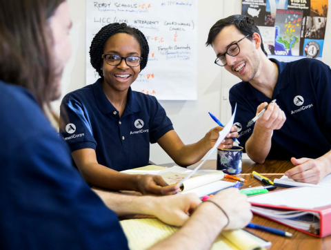 three americorps members work at desk