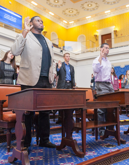 students taking an oath in a replica senate chamber