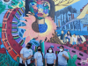 four domincan university of ca students standing in front of a colorful mural