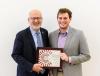 An administrator and a student holding a certificate