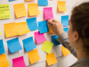 student putting post-its on a poster